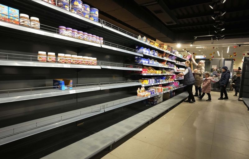 People walk next to nearly empty shelves at a shop in Nikolaev, Ukraine on March 1, 2022. Russia on Tuesday stepped up shelling of Kharkiv, Ukraine's second-largest city, pounding civilian targets there. Casualties mounted and reports emerged that more than 70 Ukrainian soldiers were killed after Russian artillery recently hit a military base in Okhtyrka, a city between Kharkiv and Kyiv, the capital. (AP/PTI Photo)