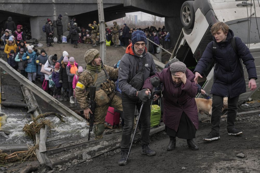 Irpin : An elderly lady is assisted to cross the Irpin river on an improvised path under a bridge, that was destroyed by Ukrainian troops designed to slow any Russian military advance, while fleeing the town of Irpin, Ukraine, Saturday, March 5, 2022. What looked like a breakthrough cease-fire to evacuate residents from two cities in Ukraine quickly fell apart Saturday as Ukrainian officials said shelling had halted the work to remove civilians hours after Russia announced the deal. AP/PTI