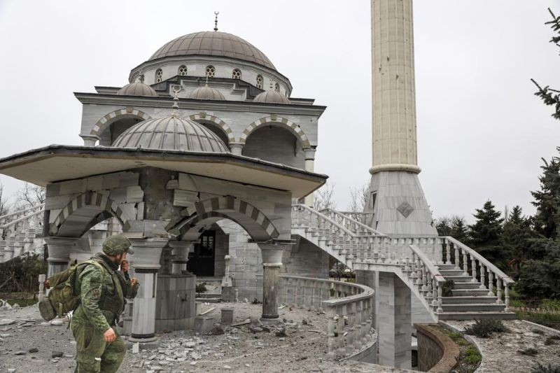 A serviceman of Donetsk People's Republic militia walks past damaged during a heavy fighting mosque in an area controlled by Russian-backed separatist forces in Mariupol, Ukraine, Tuesday, April 19, 2022. Taking Mariupol would deprive Ukraine of a vital port and complete a land bridge between Russia and the Crimean Peninsula, seized from Ukraine from 2014. (AP Photo)