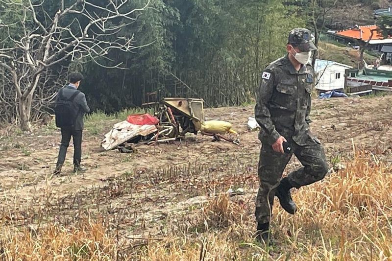 Debris from the South Korean Air force's KT-1 trainer aircraft collision are seen at a field in Sacheon, South Korea, Friday, April 1, 2022. Two South Korean air force planes collided in mid-air during training and crashed near their base on Friday, killing all four people aboard the aircraft, officials said. (AP Photo)