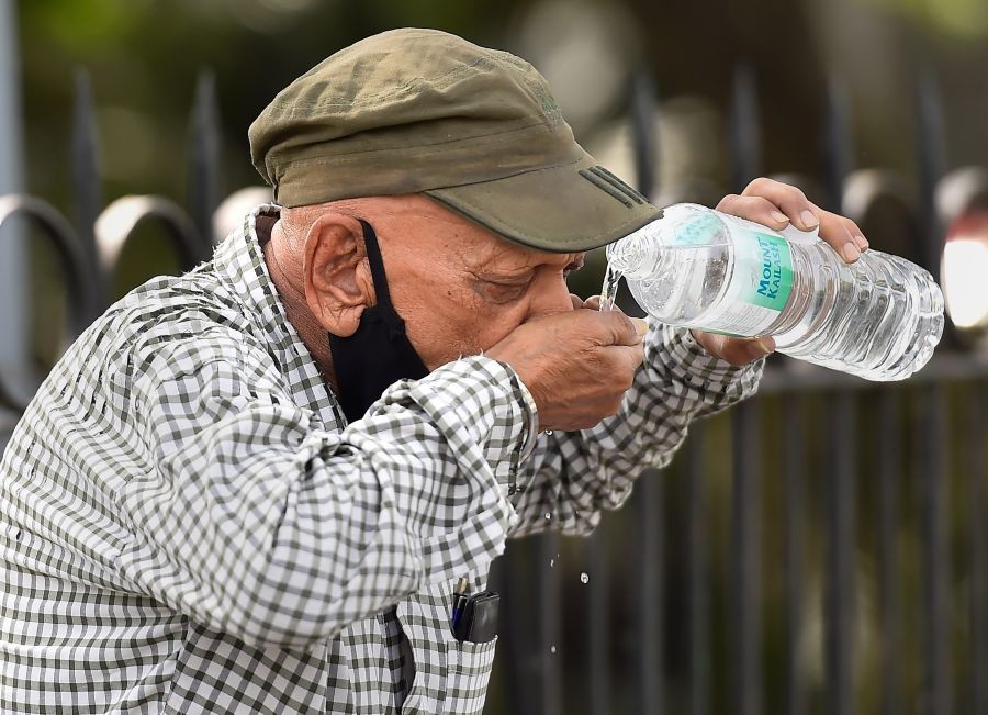 New Delhi: A pedestrian quenches his thirst on a hot summer day, at Cannaught Place in New Delhi, Sunday, April 24, 2022. (PTI Photo/Kamal Singh)