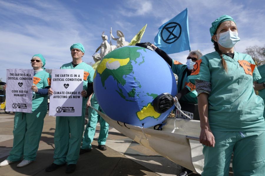 London: Demonstrators dressed as 'Planet Medics' carry an inflatable earth in Hyde Park as Extinction Rebellion continues a week of action and outreach in London, Monday, April 11, 2022.AP.PTI