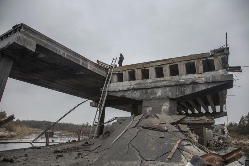 Ukrainian serviceman stand on a destroyed bridge between the village of Dytiatky and Chernobyl, Ukraine on April 5. (AP Photo)