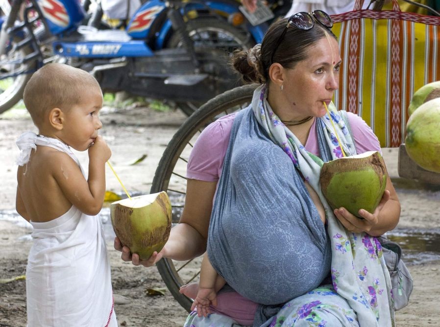 Nadia: An ISKCON member drinks coconut water along with her son, in Nadia, Saturday, April 23, 2022. (PTI Photo)