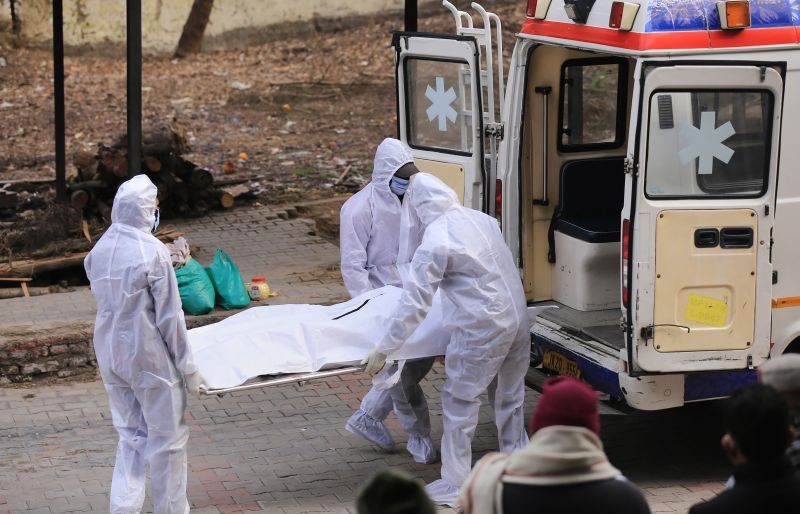Health workers wearing PPE kits carry the body of a COVID-19 victim for cremation. (PTI File Photo)