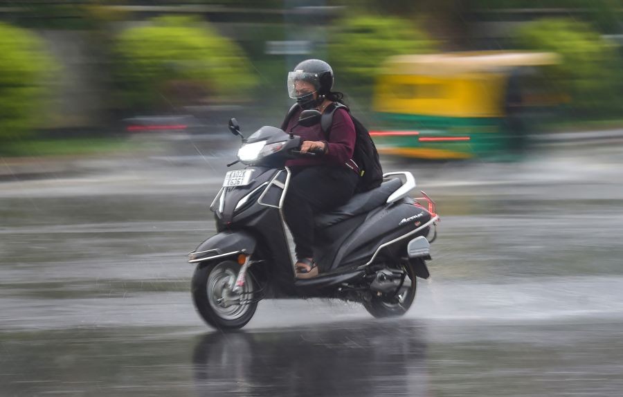Bengaluru: A commuter rides a two-wheeler amid rainfall, in Bengaluru, Monday, April 18, 2022. (PTI Photo/Shailendra Bhojak)