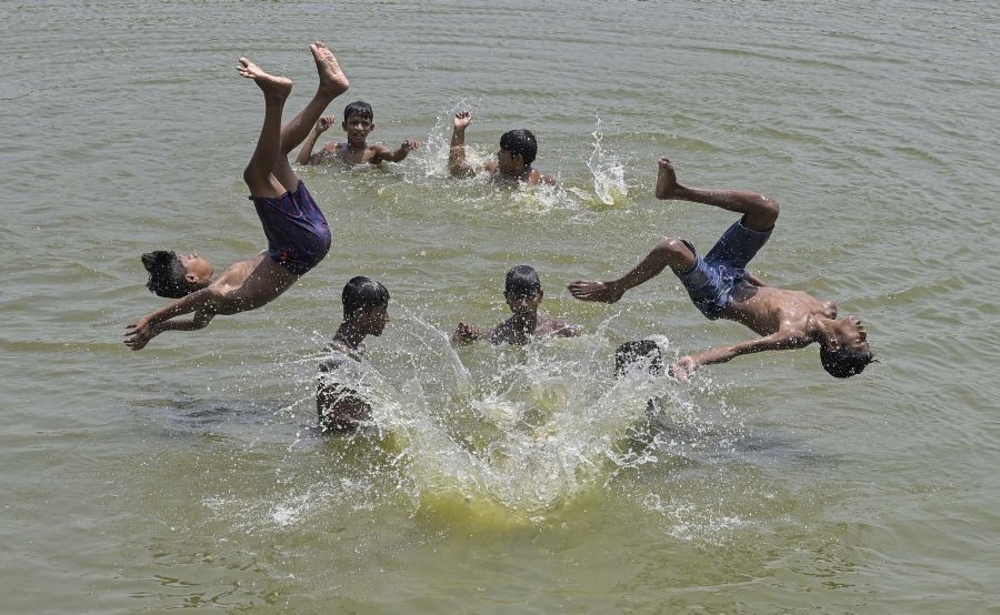 Nadia: Boys play in a waterbody to cool themselves on a hot summer day in Nadia, Tuesday, April 26, 2022. (PTI Photo)(