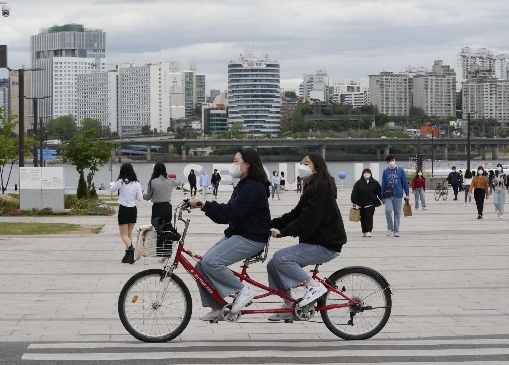 Seoul: Women wearing face masks ride a bicycle at a park in Seoul, South Korea, Friday, April 29, 2022. South Korea will ease its outdoor mask mandate starting next week as COVID-19 infections and hospitalizations continue to decline.AP/PTI Photo