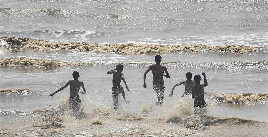 Valsad: Youngsters cool themselves in the Arabian Sea on a hot summer day, in Valsad district, Sunday, April 10, 2022. (PTI Photo)(