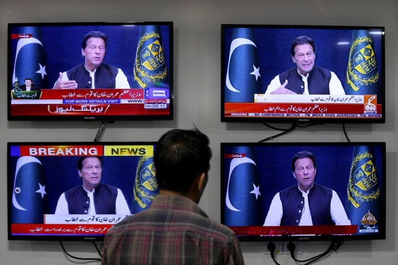 A man watches news channels broadcast a live address to the nation by Pakistan's Prime Minister Imran Khan, in Islamabad, Pakistan, Thursday, March 31, 2022. (AP File Photo)