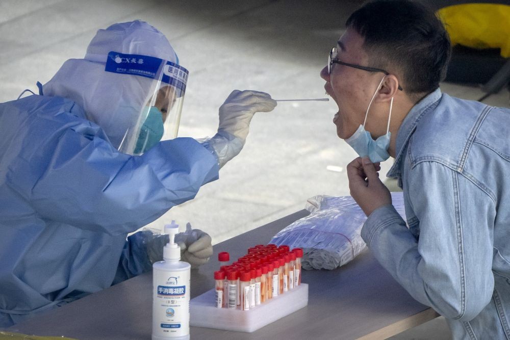 Beijing: A worker in a protective suit swabs a man's throat for a COVID-19 test at a testing site in an office complex in Beijing, Friday, April 29, 2022. AP/PTI