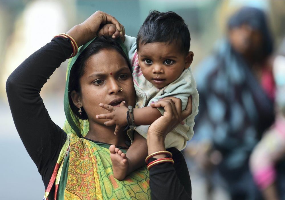 New Delhi: A labourer carries her child after the end of the day’s work, on Mother’s Day, in New Delhi, Sunday, May 8, 2022. (PTI Photo/Kamal Kishore)