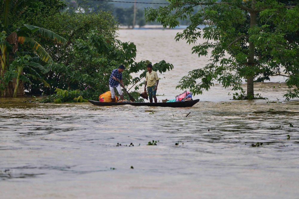 Nagaon: Villagers use a boat to move from a flooded area to safer places after rain at a village in Nagaon district, Tuesday, May 17, 2022. (PTI Photo)
