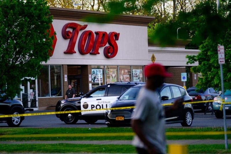 A person walks past the scene of a shooting at a supermarket, in Buffalo, N.Y., Sunday, May 15, 2022. (AP Photo)