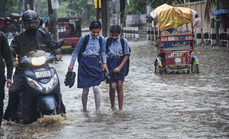Guwahati: School students wade through a waterlogged street after rain at Anil Nagar in Guwahati, Friday, May 13, 2022. (PTI Photo)