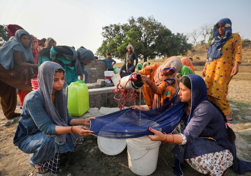 Women use a cloth to filter drinking water after collecting it from a well, at Padal village in Samba district on May 1, 2022. India is facing a brutal spell of heatwave, which has led to water shortages in many parts of the country. (PTI Photo)