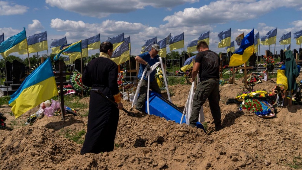 Undertakers lower the coffin of Ukrainian serviceman Oleksander Matyukhin, 32, in Kharkiv, eastern Ukraine, Monday, May 23, 2022. (AP Photo/Bernat Armangue)