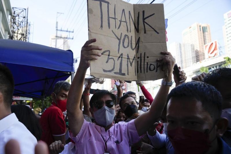 Presidential candidate Ferdinand "Bongbong" Marcos Jr. holds a sign he got from the crowd as he celebrates outside his headquarters in Mandaluyong, Philippines on May 11, 2022. Marcos' apparent landslide victory in the Philippine presidential election is raising immediate concerns about a further erosion of democracy in Asia and could complicate American efforts to blunt growing Chinese influence and power in the Pacific. (AP Photo)