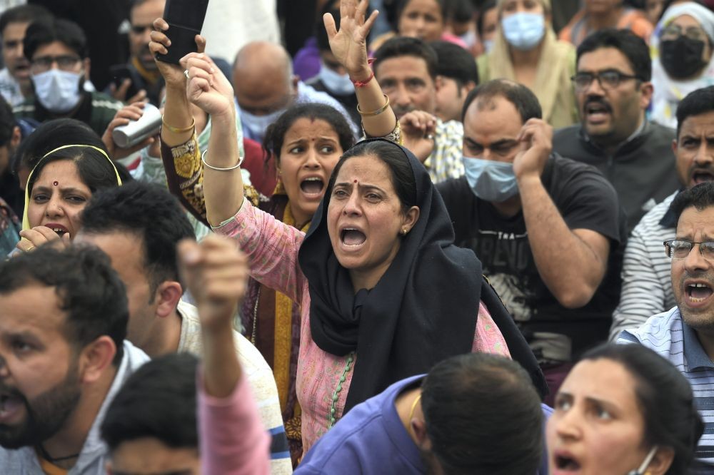 Budgam: Kashmiri pandits shout slogans while blocking a road during their protest over the killing of Rahul Bhat, who was shot at by militants inside his office and later succumbed to injuries, at Sheikh Pora in Budgam district, Thursday, May 12, 2022. (PTI Photo/S. Irfan)