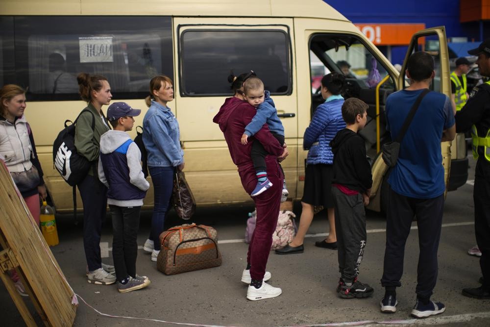 People wait to be processed upon their arrival at a reception center for displaced people in Zaporizhzhia, Ukraine, Monday, May 2, 2022. Thousands of Ukrainian continue to leave Russian occupied areas. (AP Photo/Francisco Seco)