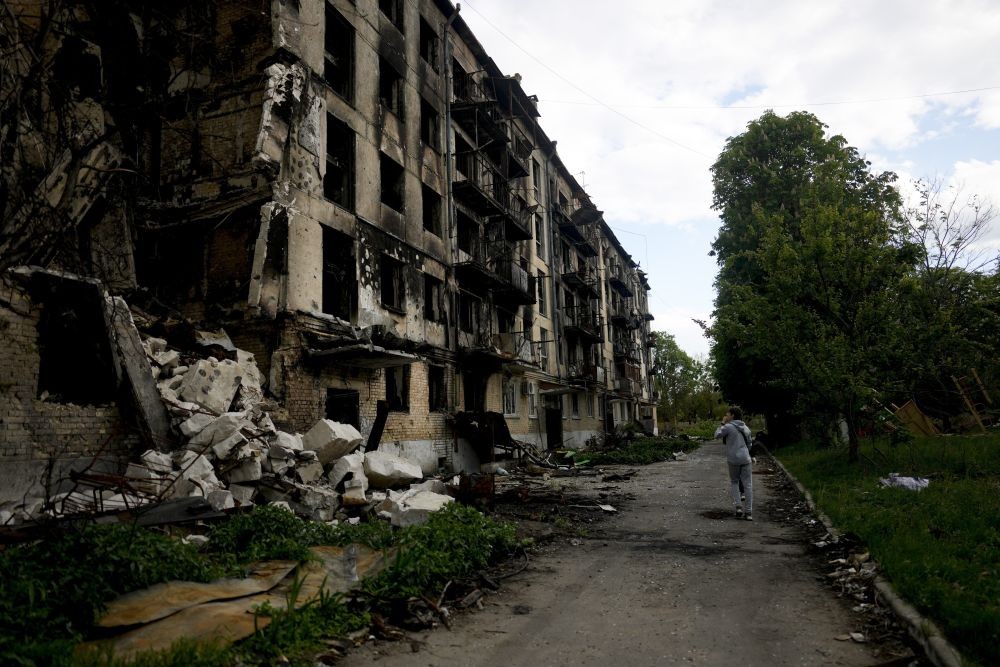 A man walks in front of a damage building ruined by attacks in Hostomel, outskirts Kyiv, Ukraine, Thursday, May 26, 2022. AP/PTI(