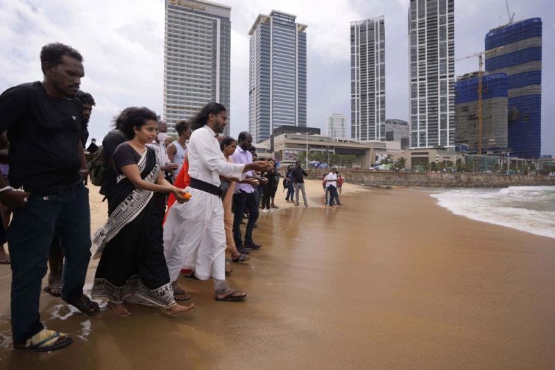 Human rights activists walk to offer flowers to the sea in remembrance of victims of Sri Lanka's civil war, at the ongoing anti government protest site in Colombo, Sri Lanka, Wednesday, May 18, 2022. Sri Lankan protesters lit flames and offered followers on Wednesday remembering thousands including ethnic Tamil civilians killed in the final stages of the country's long civil war, in the first-ever event where mostly majority ethnic Sinhalese openly memorialised the minority group. (AP Photo)
