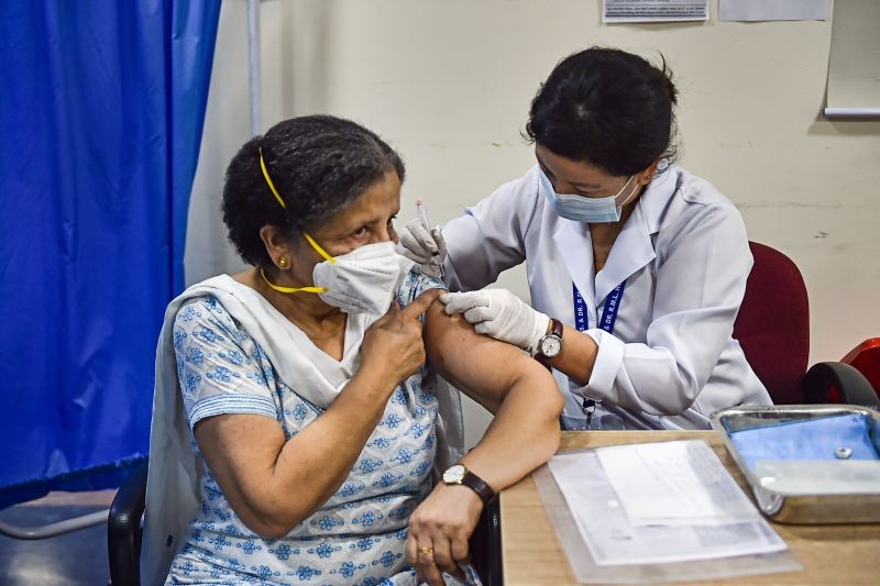 A health worker administers a dose of COVID-19 preventive vaccine to an elderly woman, amid rise in coronavirus cases, at RML Hospital in New Delhi on May 2. (PTI Photo)