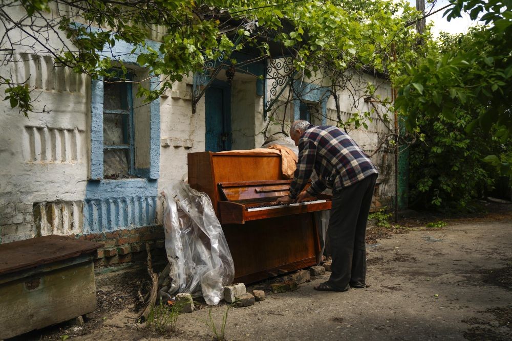 Local resident Anatolii Virko plays a piano outside a house likely damaged after a Russian bombing in Velyka Kostromka village, Ukraine, Thursday, May 19, 2022. (AP/PTI)