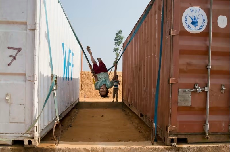 Rohingya refugee girl Azida plays on a makeshift swing tied to World Food Program (WFP) containers inside Balukhali refugee camp near Cox's Bazar, in Bangladesh. (AP File Photo)