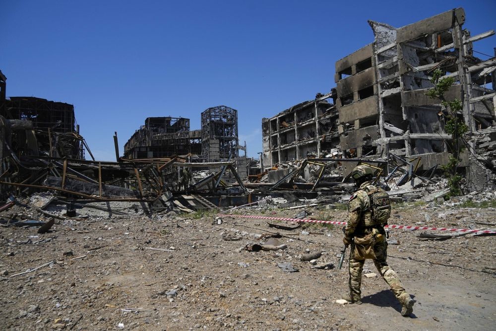A Russian soldier walks in front of the damaged Metallurgical Combine Azovstal plant, in Mariupol, on the territory which is under the Government of the Donetsk People's Republic control, eastern Ukraine, Monday, June 13, 2022. The plant was almost completely destroyed during the siege of Mariupol. This photo was taken during a trip organized by the Russian Ministry of Defense. (AP Photo)(