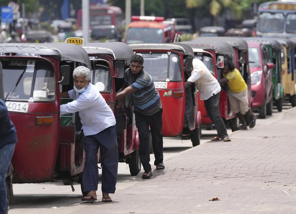 FILE- Sri Lankan auto rickshaw drivers queue up to buy petrol near a fuel station in Colombo, Sri Lanka, April 13, 2022. Sri Lankans are facing a severe economic crisis that has ravaged household budgets amid high inflation. Staple foods are in short supply, along with medicines.(AP Photo/Eranga Jayawardena, File)