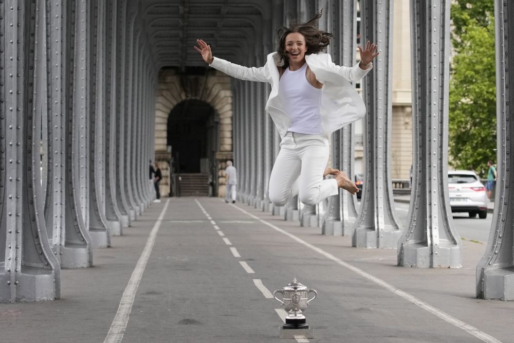 Poland's Iga Swiatek jumps next to her trophy in Paris, France, Sunday, June 5, 2022, after she won Saturday's women's final match at the French Open tennis tournament in Roland Garros stadium. AP/PTI