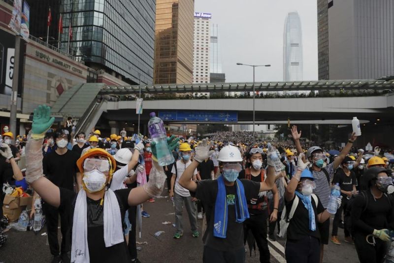 Protesters gesture to riot police during a massive demonstration outside the Legislative Council in Hong Kong on June 12, 2019. When the British handed its colony Hong Kong to Beijing in 1997, it was promised 50 years of self-government and freedoms of assembly, speech and press that are not allowed Chinese on the Communist-ruled mainland. As the city of 7.4 million people marks 25 years under Beijing's rule on Friday, those promises are wearing thin. Hong Kong's honeymoon period, when it carried on much as it always had, has passed, and its future remains uncertain, determined by forces beyond its control. (AP File Photo)