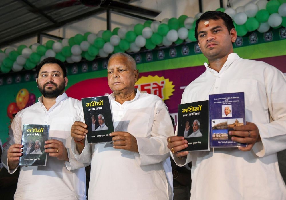Patna: RJD Chief Lalu Prasad Yadav along with his sons Tejashwi Yadav and Tej Pratap Yadav releases a book titled 'Garibo Ka Masiha', during celebrations of his 75th birthday, in Patna, Saturday, June 11, 2022. (PTI Photo)