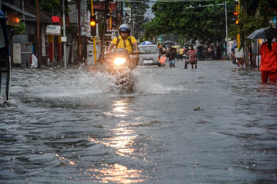 Agartala: Commuters wade through a flooded street after monsoon rains, in Agartala, Friday, June 17, 2022. (PTI Photo)