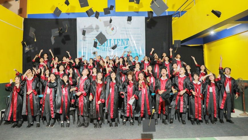 The graduating Class of 2022 of Hope Academy toss their caps in celebration during the programme on June 18.