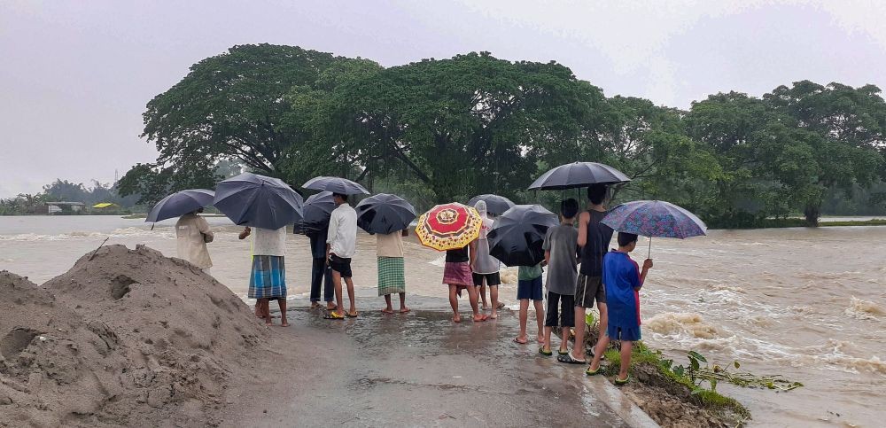Baksa: Flood-affected people stand on a road damaged by the flooded Pagladiya river, at Goalbil village, in Baksa district, Thursday, June 16, 2022. (PTI Photo)
