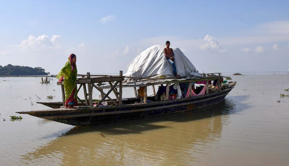 Morigaon: Villagers take shelter on an abandoned boat, at the flood-affected Chanaka village, in Morigaon district, Wednesday, June 22, 2022. (PTI Photo)