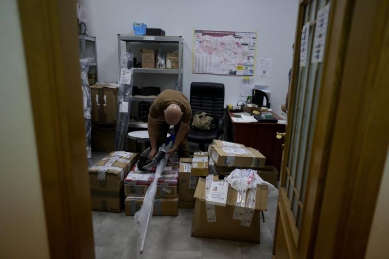A volunteer prepares boxes of goods to be delivered to soldiers fighting on the eastern and southern fronts, dispatched from an NGO storage center in Kyiv, Ukraine on June 13, 2022. In the war in Ukraine, troops on both sides are getting supplies from crowd-funders. On the Ukrainian side, the self-starting networks of donors and volunteers are particularly large, spontaneous and well-oiled. At a critical juncture of the invasion, their deliveries of drones, high-tech optical gear, vehicles and other equipment are keeping Ukraine in the fight against its better-supplied aggressor. (AP Photo)
