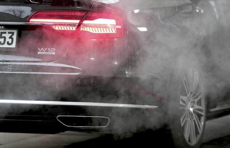 A luxury Audi car is surrounded by exhaust gases as it is parked with a running engine in front of the Chancellery in Berlin, Germany, Wednesday, Nov. 20, 2019. Germany's transport minister said Thursday that he opposes plans to ban the sale of new cars with combustion engines across the European Union in 2035, arguing this would discriminate against vehicles powered with synthetic fuels. EU lawmakers voted Wednesday to back the measure that requires automakers to cut carbon-dioxide emissions by 100% by the middle of the next decade, effectively prohibiting the sale in the 27-nation bloc of new cars powered by gasoline or diesel. (AP File Photo)