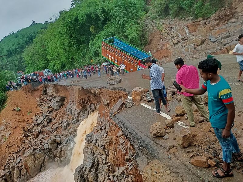 People gather near a truck after it crashed as some part of the National Highway 6 (NH06) under Lumshnong Police Station's jurisdiction caved in due to a landslide after heavy rains, in Meghalaya's East Jaintia Hills district. (PTI Photo)