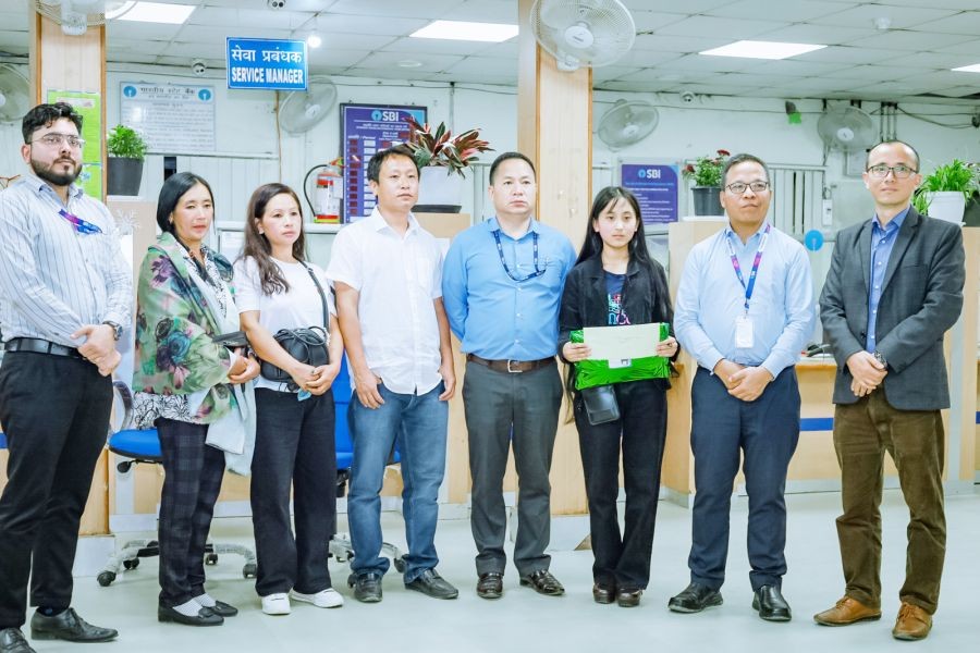 Sangyuchenla Chang who secured 9th position in the HSLC examination 2022 with SBI Tuensang officials and others during the felicitation programme. (Morung Photo)