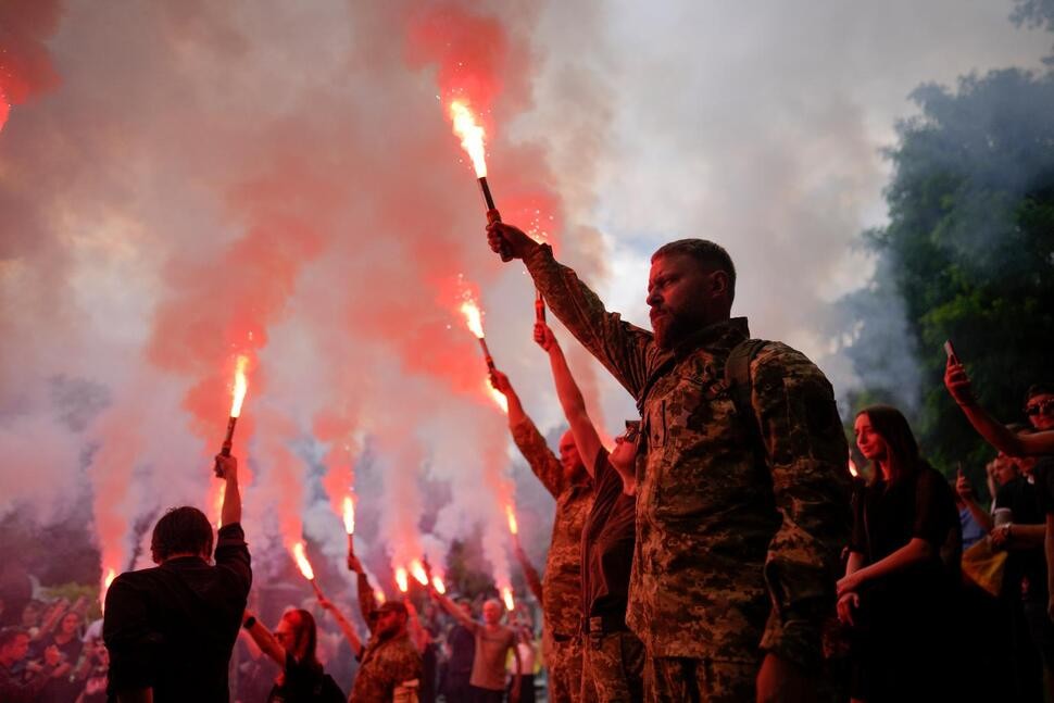 Soldiers hold flares as they attend the funeral of activist and soldier Roman Ratushnyi in Kyiv, Ukraine, Saturday, June 18, 2022. Ratushnyi died in a battle near Izyum, where Russian and Ukrainian troops are fighting for control of the area. (AP Photo/Natacha Pisarenko) THE ASSOCIATED PRESS
