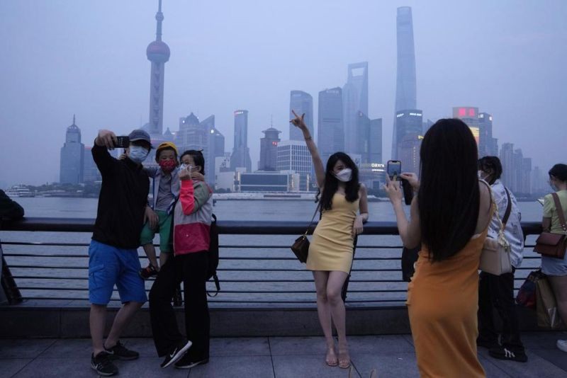 Residents pose for photos along the bund, Wednesday, June 1, 2022, in Shanghai. Traffic, pedestrians and joggers reappeared on the streets of Shanghai on Wednesday as China's largest city began returning to normalcy amid the easing of a strict two-month COVID-19 lockdown that has drawn unusual protests over its heavy-handed implementation. (AP Photo)