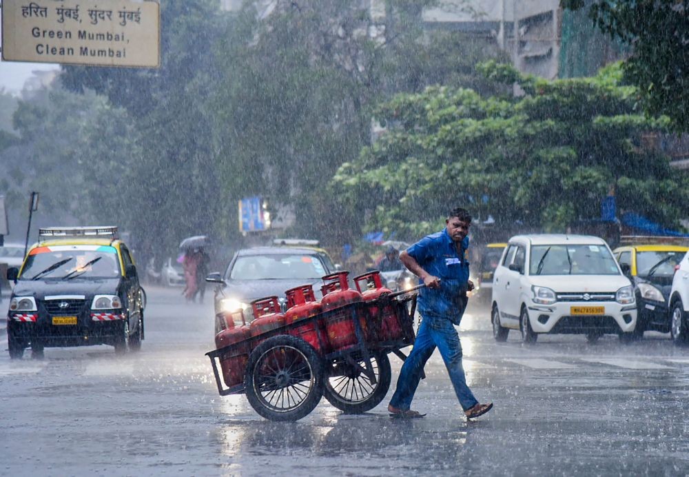 Mumbai: Commuters move on a road amid monsoon rains, in Mumbai, Monday, July 4, 2022. (PTI Photo)