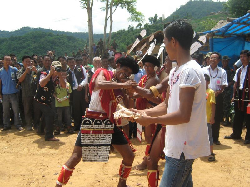 A man takes bite off a chunk of pork fat during a traditional meat-eating competition held as part of Tuluni Festival celebration. (Morung File Photo)