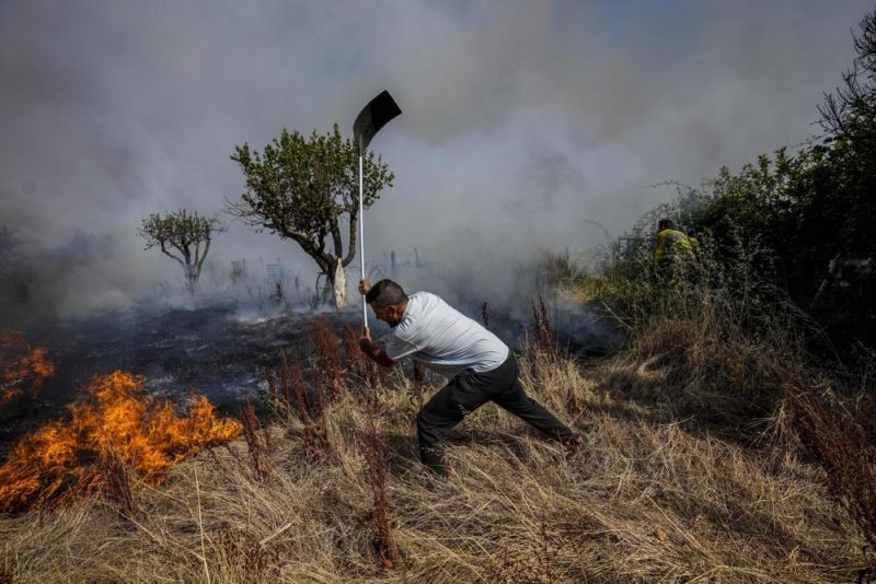 A local resident fights a forest fire with a shovel during a wildfire in Tabara, north-west Spain, July 19, 2022. (AP File Photo)