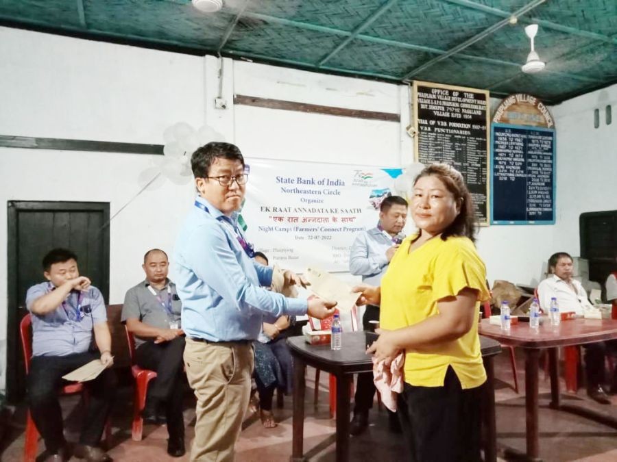 An SBI official handing out an award to an SHG member during the farmers’ connect programme at in Phaipijang village on July 22.