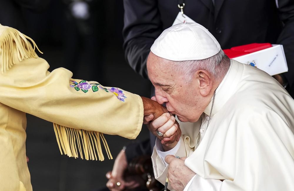 Pope Francis kisses the hand of residential school survivor Elder Alma Desjarlais of the Frog Lake First Nation as he arrives in Edmonton, Alberta, Canada, on Sunday, July 24, 2022. The pope's visit to Canada is aimed at reconciliation with Indigenous people for the Catholic Church's role in residential schools. (Nathan Denette/The Canadian Press via AP)