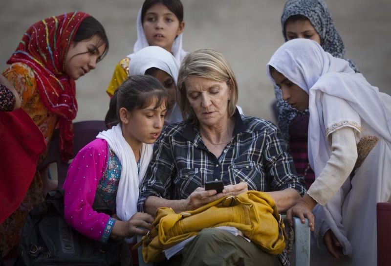 In this Saturday, October 1, 2011 file photo, Associated Press Special Regional Correspondent for Afghanistan and Pakistan Kathy Gannon sits with girls at a school in Kandahar, Afghanistan. A Kabul court announced on July 23, 2014 that the Afghan police officer charged with killing Associated Press photographer Anja Niedringhaus and wounding veteran AP correspondent Kathy Gannon has been convicted and sentenced to death. (AP File Photo)